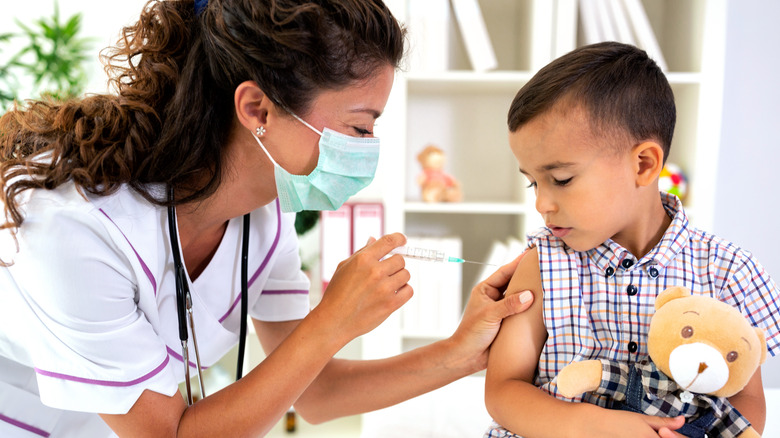 Doctor giving child vaccine shot in arm