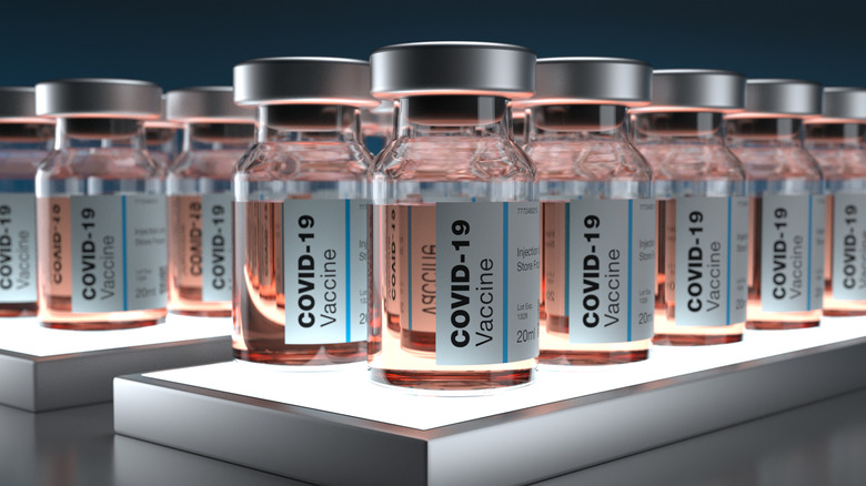 Close up of several vials labeled COVID-19 vaccine