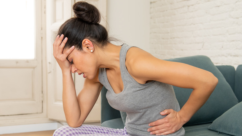 Woman with headache and stomach pain