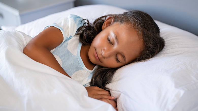 Young girl asleep in bed