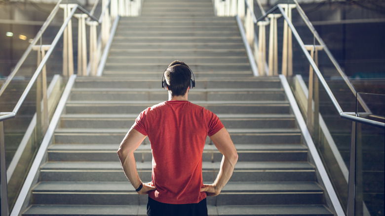 Man with headphones looking at staircase