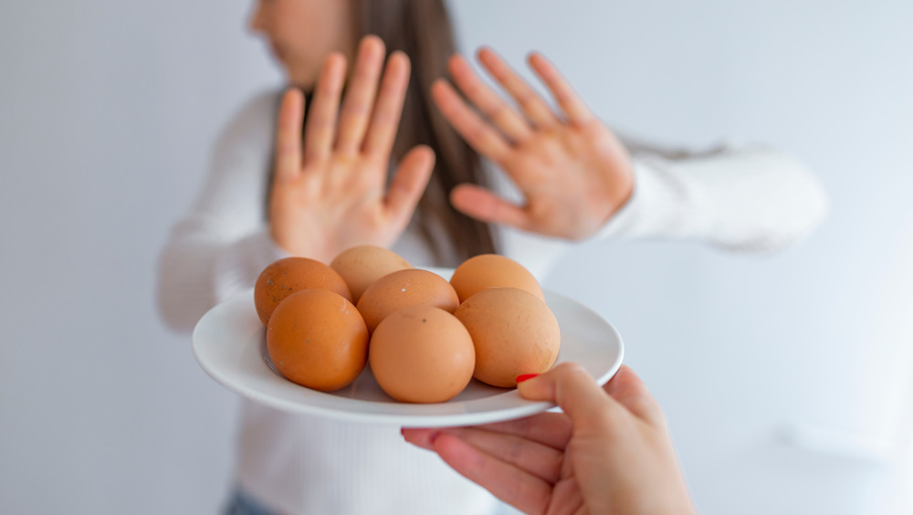 a woman rejecting a plate of eggs 