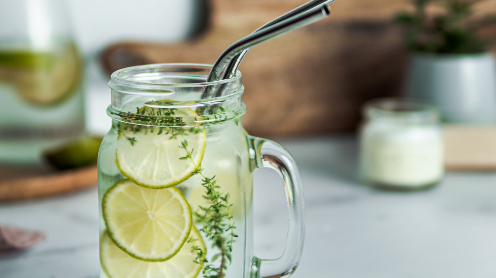 Lime infused water in mason jar glass with straws